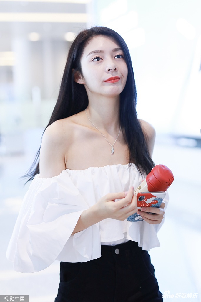 组图:傅菁穿落肩白衣秀"锁骨杀" 手捧玫瑰红唇美艳美腿纤长