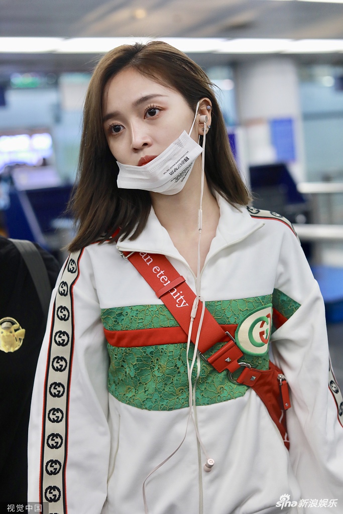 组图:吴宣仪精致装扮半戴口罩现身机场 眼神呆萌面带倦容