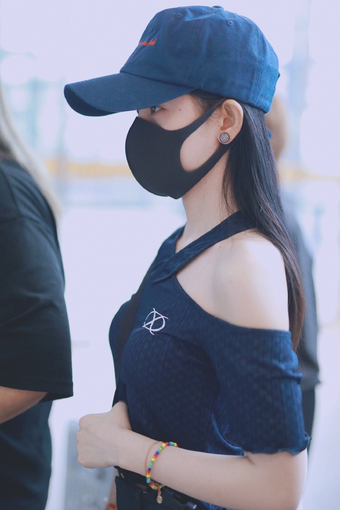 组图鞠婧祎戴口罩现身机场穿交叉带露肩上衣秀雪肤