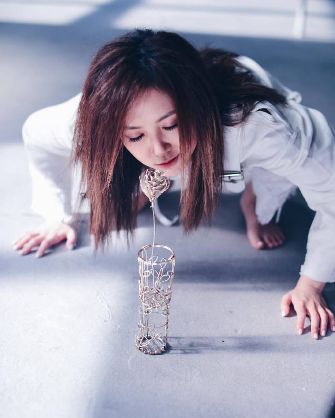 组图:邓紫棋mv花絮照蹲地嗅假花 头发蓬乱眼神恍惚气氛诡谲