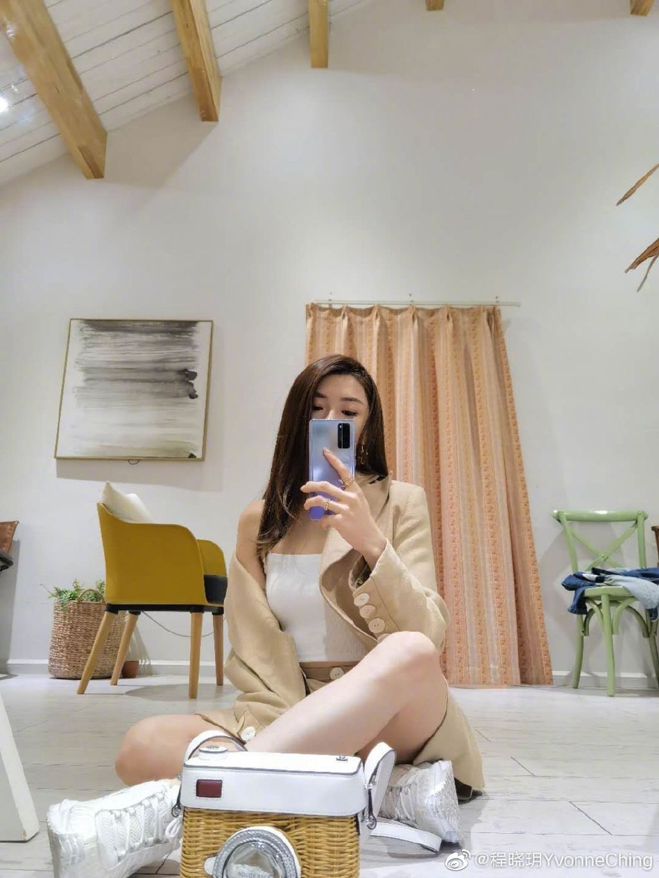 "照片中程晓玥身穿白色吊带,搭配驼色休闲