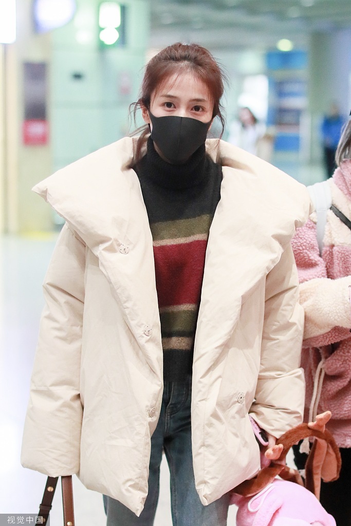 组图:白鹿穿羽绒服搭机清新甜美 获赠史迪仔玩偶笑眼弯弯
