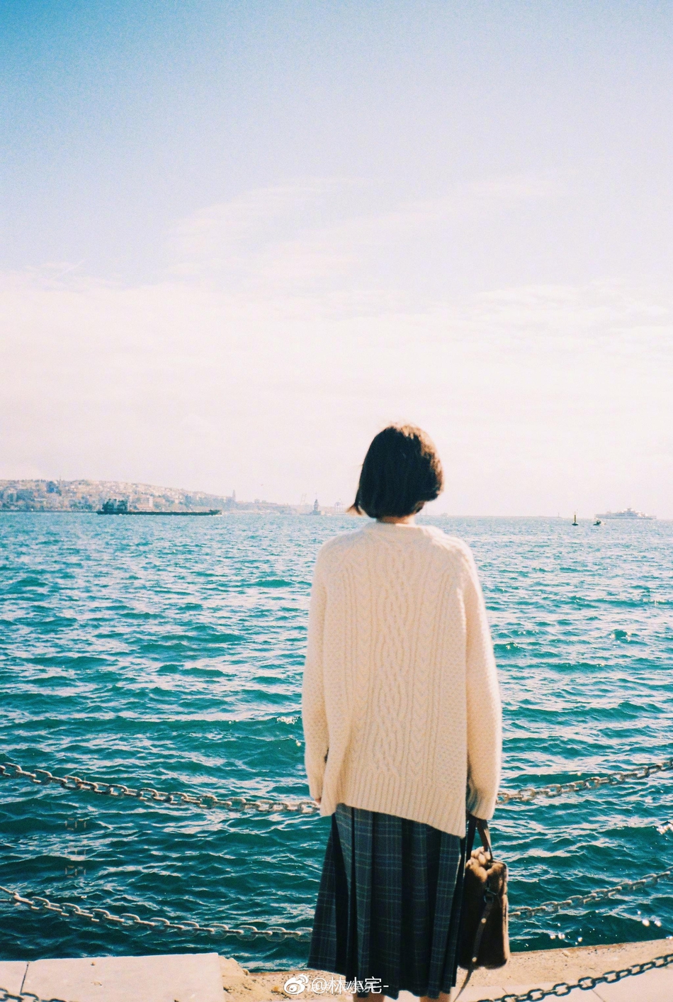 网红美女林小宅晒出一组土耳其游玩照,身穿白色毛衣的她站在海边,配合