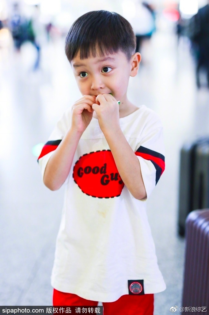 组图:邓莎大麟子着亲子装现身机场 大麟子零食不停