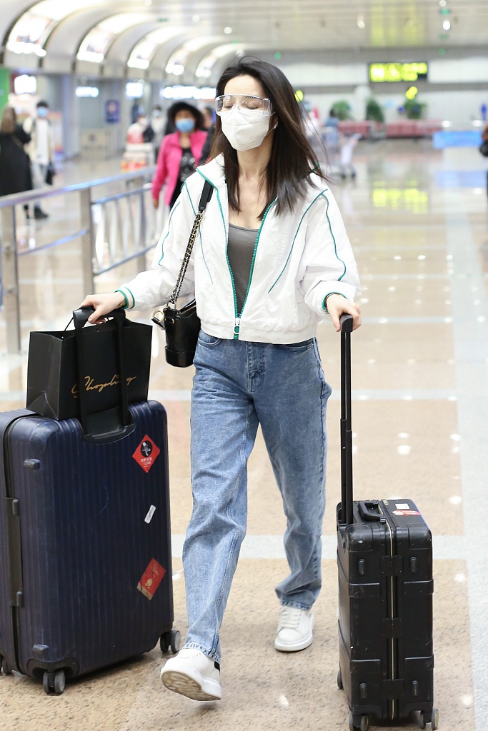 组图:代斯装扮简约眉眼温柔清纯 推俩行李箱赶路变女汉子