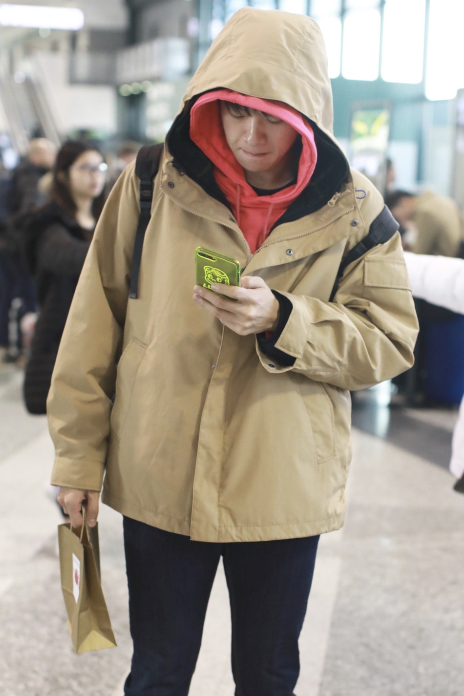 组图:魏大勋素颜低调现身机场 叠戴帽子煲电话粥表情呆萌