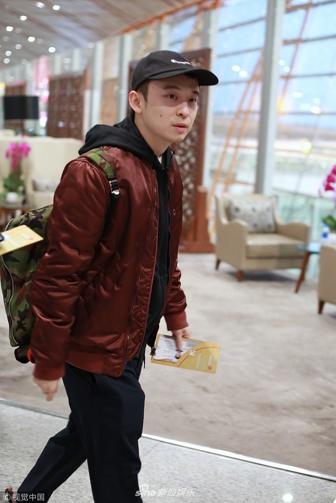 组图:"奶爸"董子健嘴叼机票 认真剥糖纸悠闲排队