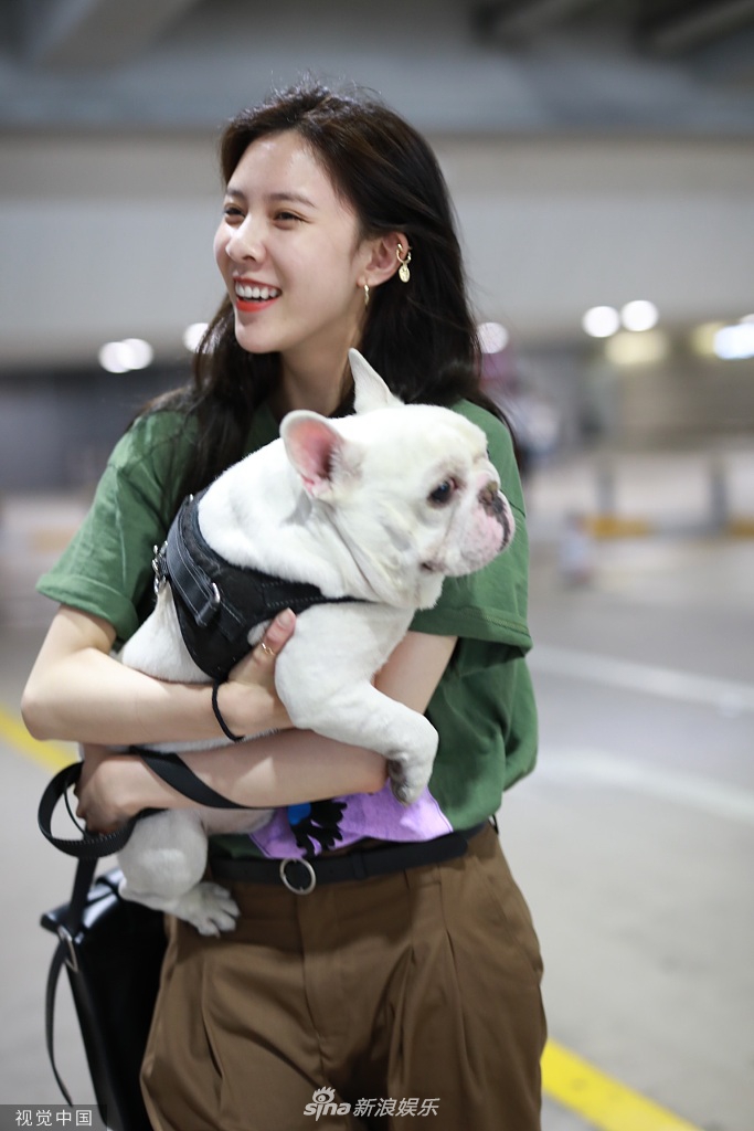 组图:宋妍霏抱爱犬现身机场 心情大好笑的见牙不见眼