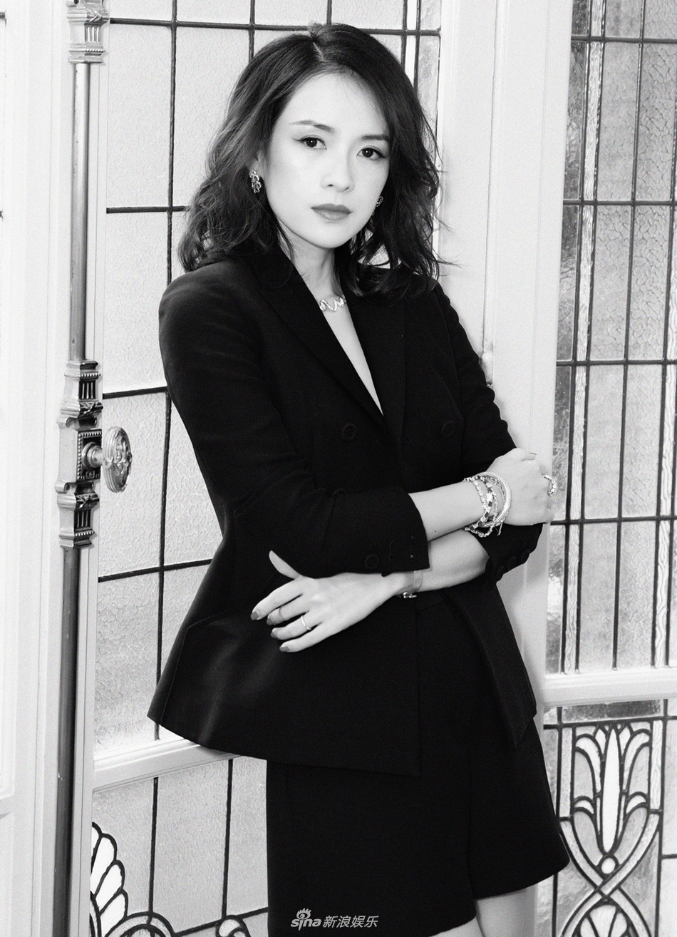 章子怡一身黑色西装低调出席,手持折扇的她在阳光下笑容盈盈.