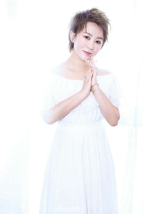 a面,身穿一袭白色长裙,微风吹过波动裙摆,十分飘逸