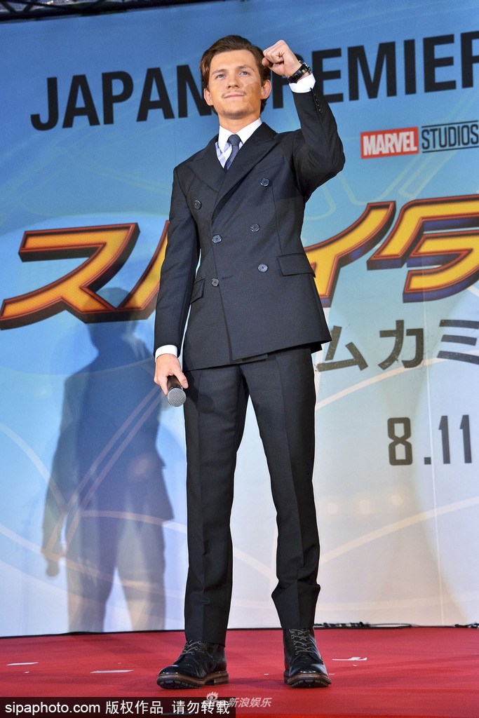 组图:男星汤姆·赫兰德西装亮相 对粉丝热情打招呼