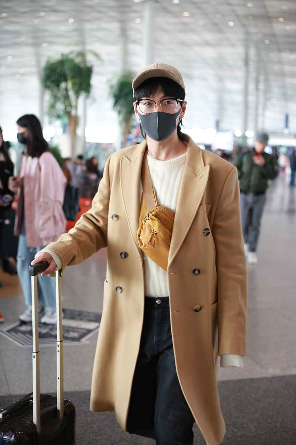 韩火火素颜出发上海维密 驼色大衣棒球帽秀慵懒男友穿搭