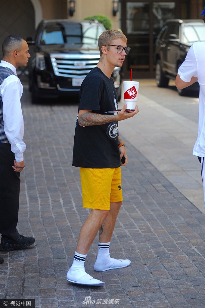 组图:比伯黑t短裤见镜头大方挥手 超大杯饮料很抢镜