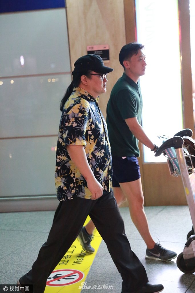 刘欢梳长马尾现身机场 穿海滩风花衬衫脖子比脸粗