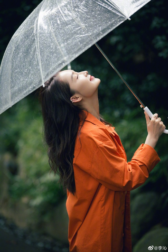 组图:李沁穿橘色外套雨中漫步显文艺 手持透明伞上演唯美侧颜杀