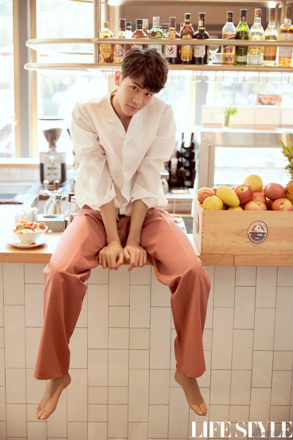 镜头中,梁译木身着暖色系潮装,时而把玩复古相机