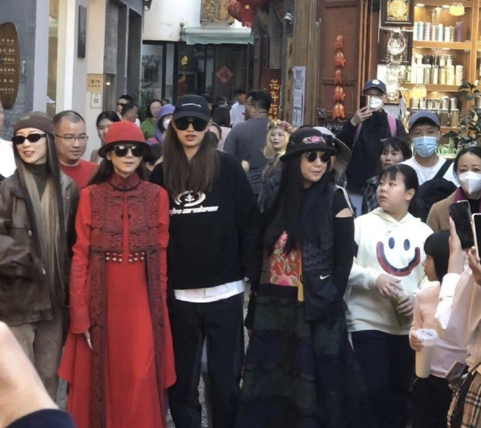 组图：杨丽萍穿红色民族服饰出街抢眼 与徒弟一行人戴墨镜气场强