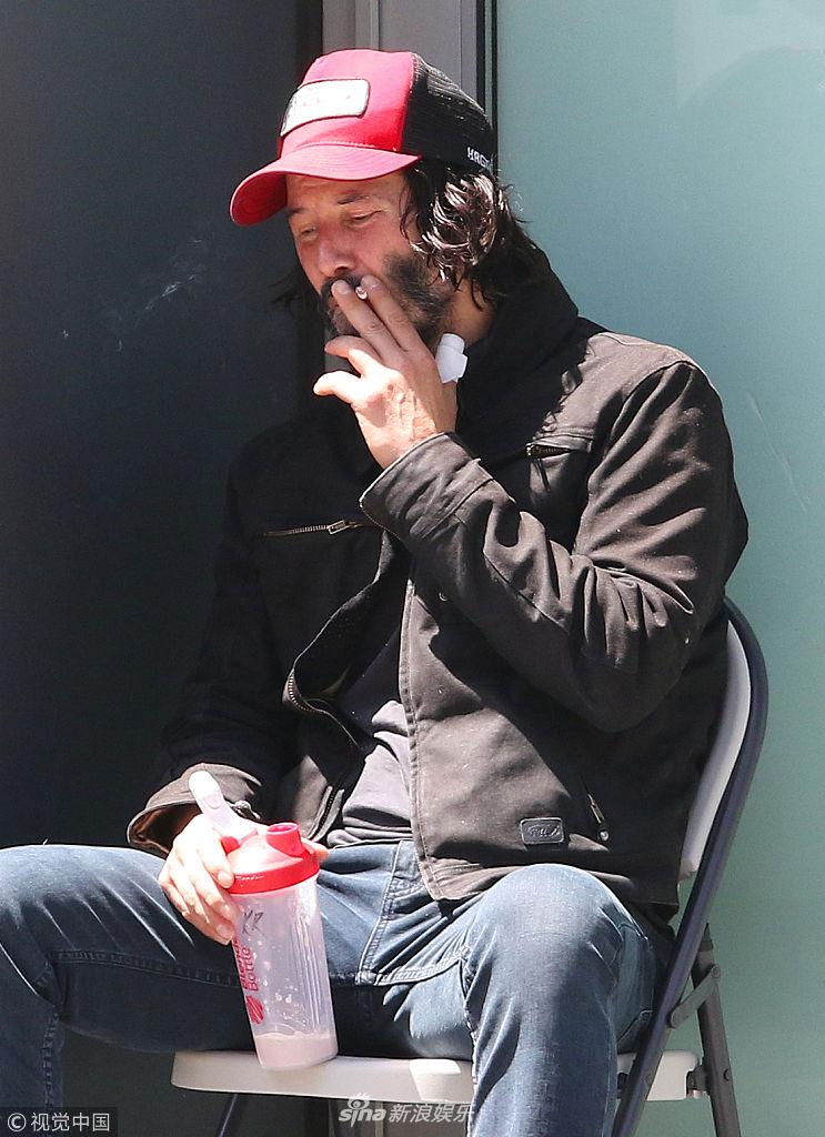 基努·里维斯坐角落抽烟喝水休