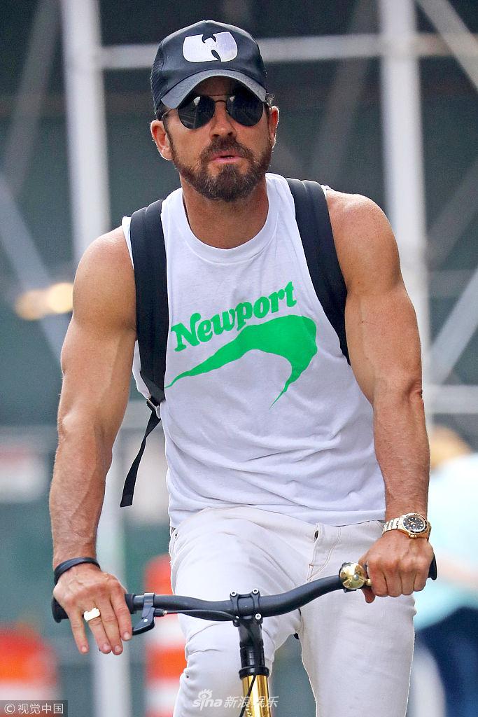 组图:安妮斯顿老公贾斯汀街头骑单车 手臂肌肉健硕格外抢眼