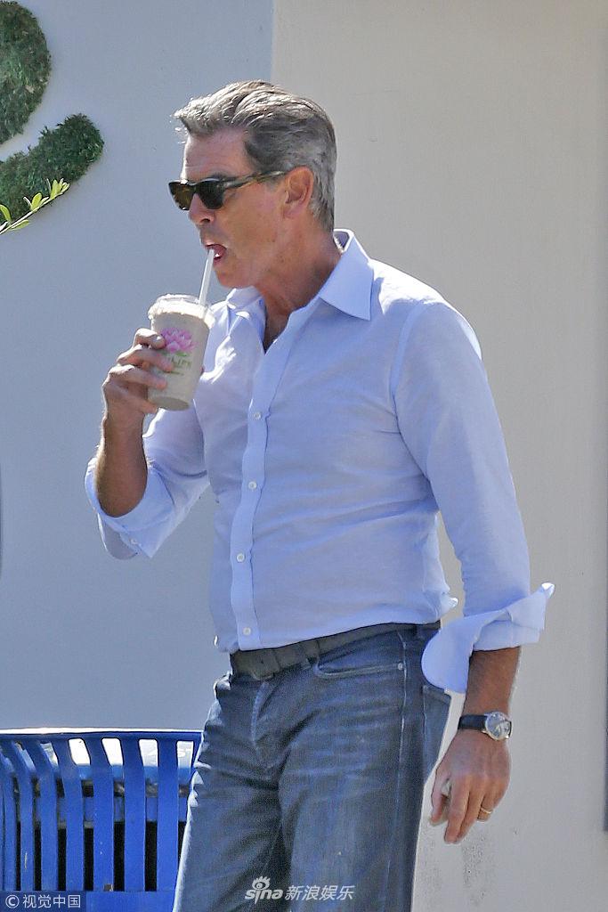 组图:"最帅007"布鲁斯南街边喝奶茶 穿蓝衬衫显绅士风度