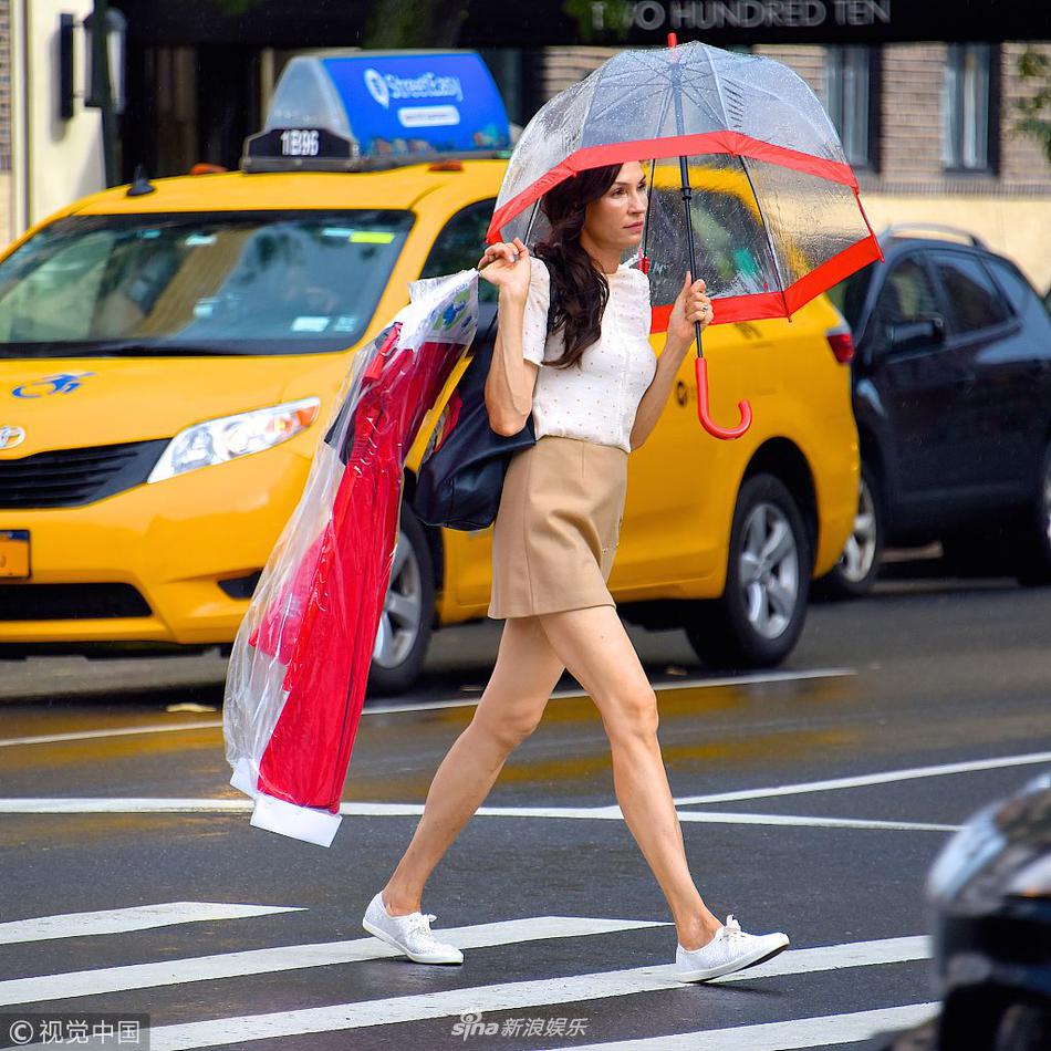 组图:法米克·詹森披衣服上街cos女侠 打奇怪雨伞咬嘴唇显俏皮