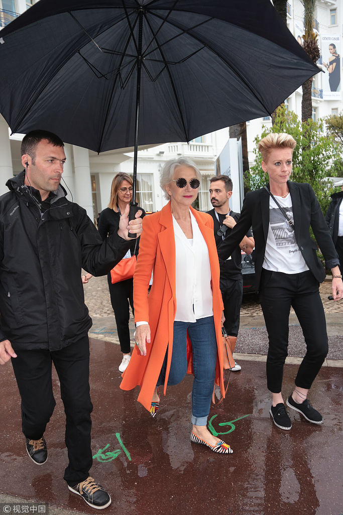 组图:73岁海伦·米伦橘色开衫显活力 获专人撑伞出街似女王