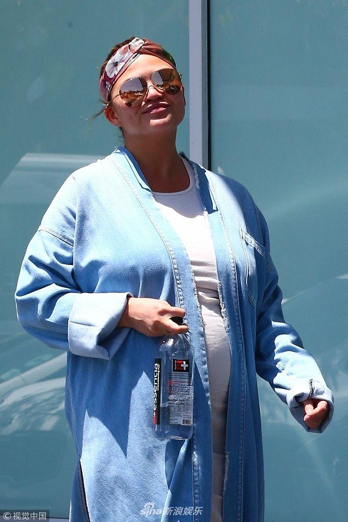 组图:克莉茜·泰根冲镜头俏皮点赞 怀孕发福获"传奇哥"护驾