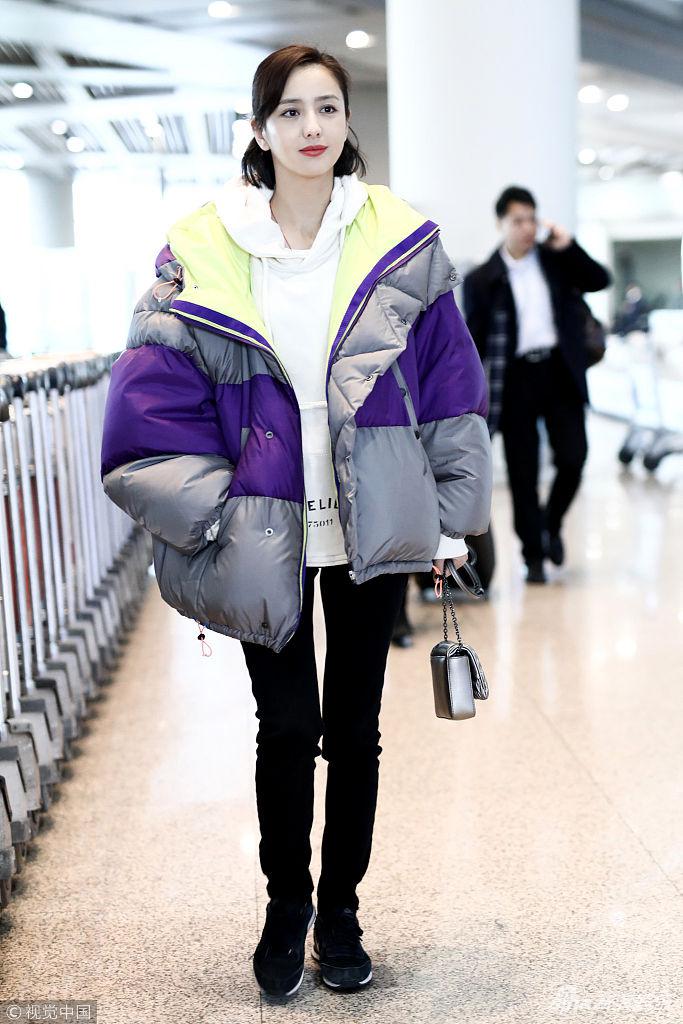 佟丽娅穿oversize羽绒服秀纤细美腿,她冲镜头比v发射爱心,捂嘴甜笑