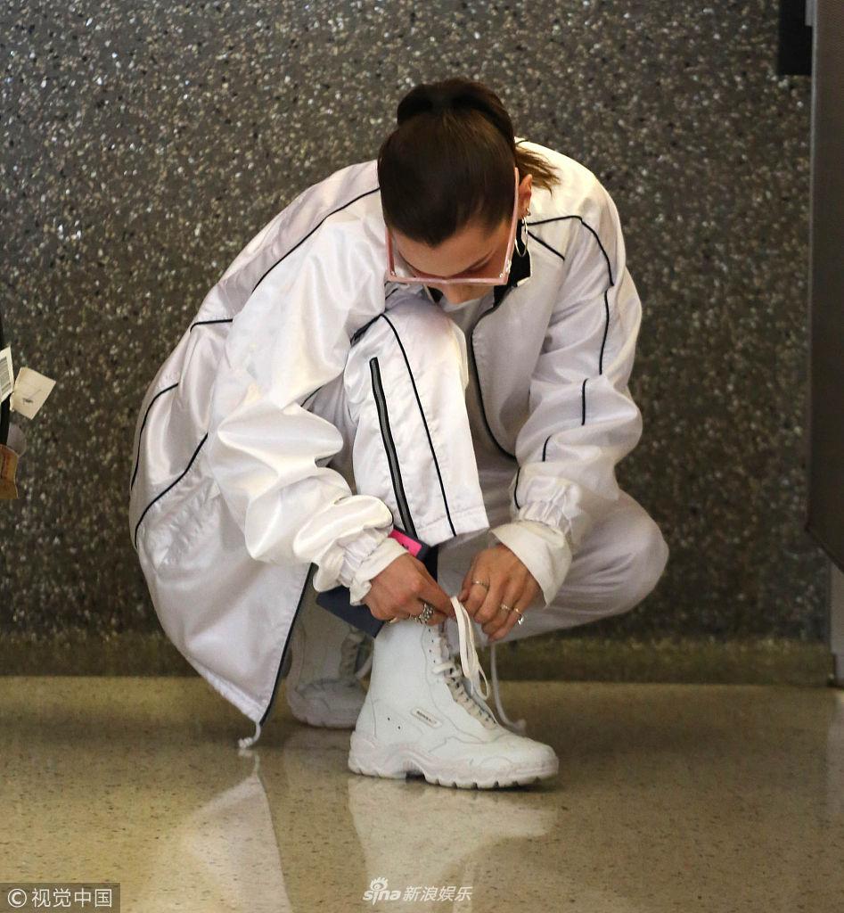 组图:贝拉·哈迪德全白look玩时尚 挡脸防拍蹲下系鞋带帅气撩人