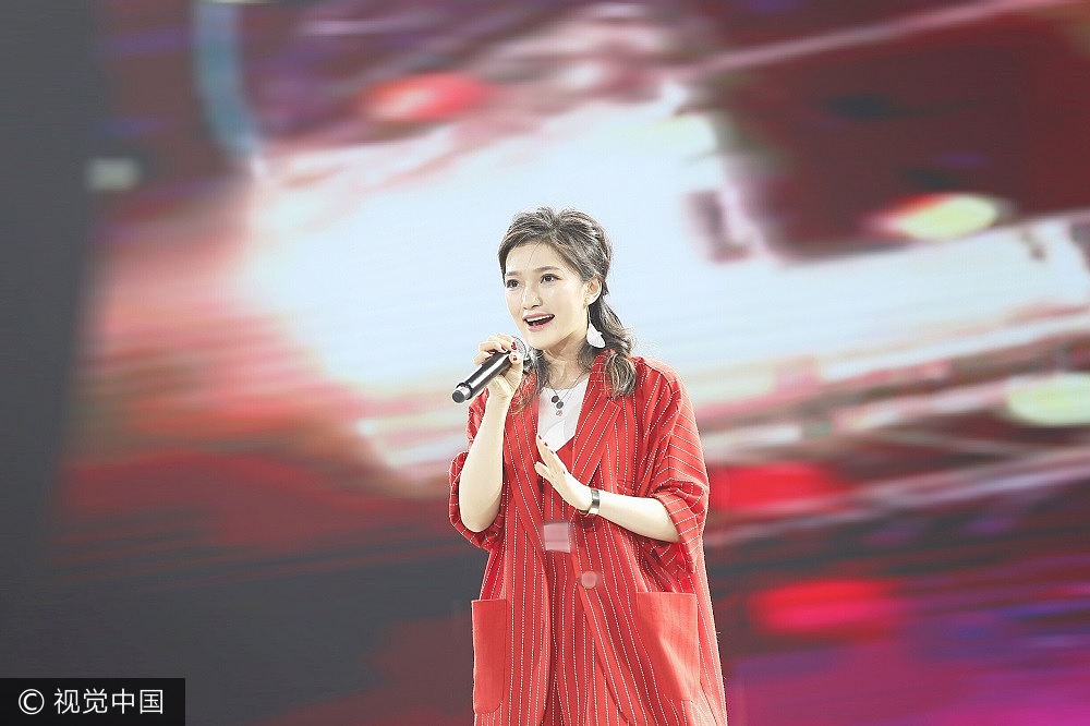 组图好声音丁丁甜美献唱大红条纹套装秀美腿