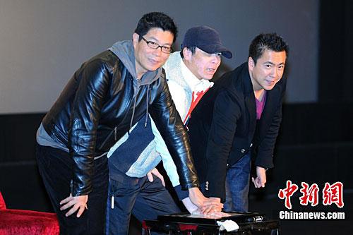 原料图:2010年,冯幼刚与王中军(左)、王中磊(右)共同按下“手印”,宣布再次续约华谊又签五部新片的计划 中新社记者 李学仕 摄