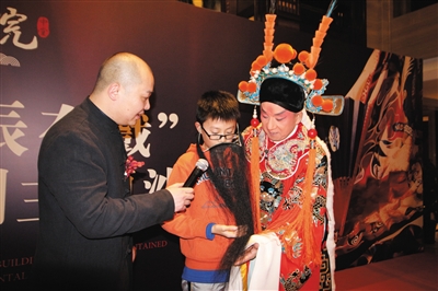 一名小票友上台，由何威老师亲自指导相关表演动作。