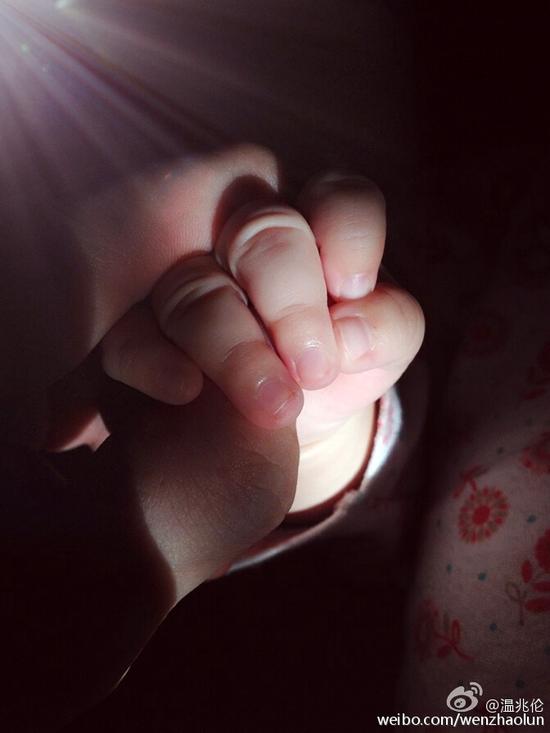 温兆伦[微博]晒出和女儿的牵手照片,女儿小小的手窝在爸爸厚重的掌心