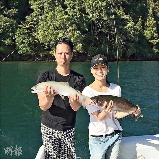 胡杏儿与老公李乘德各自捧着一条鱼拍照。