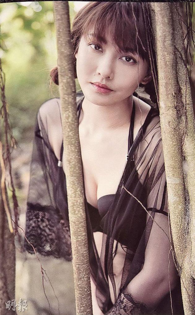 穿着性感比基尼的李彩华站在树后展现美感。