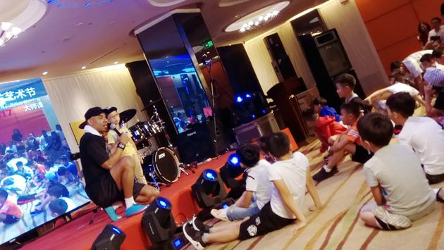 信乐团鼓手Michael（黄迈可）正在跟小学员互动