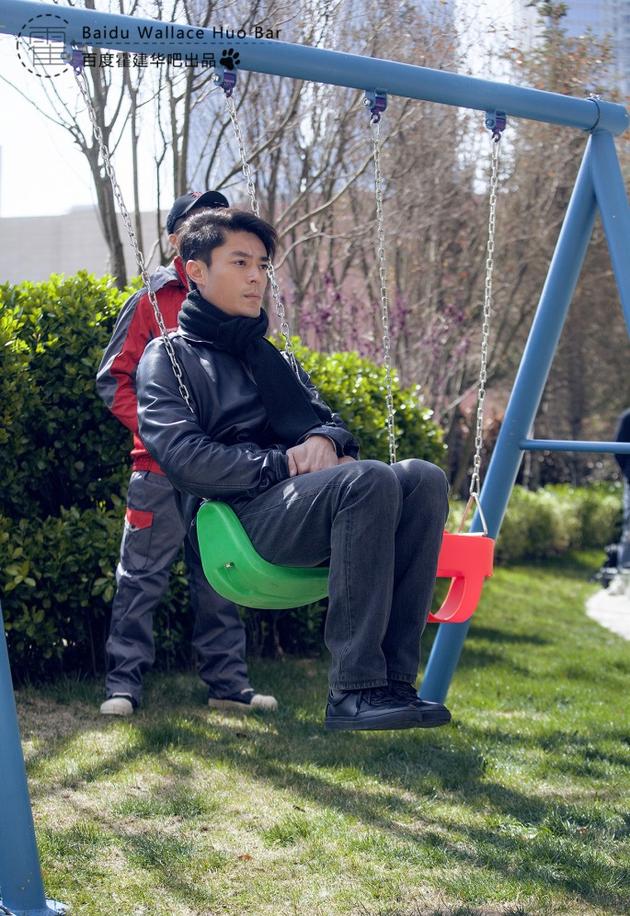 霍建华坐在儿童秋千上
