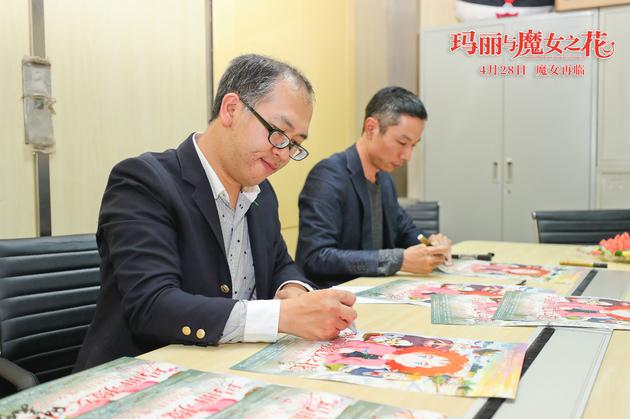导演与制片人在给中国影迷签名海报。