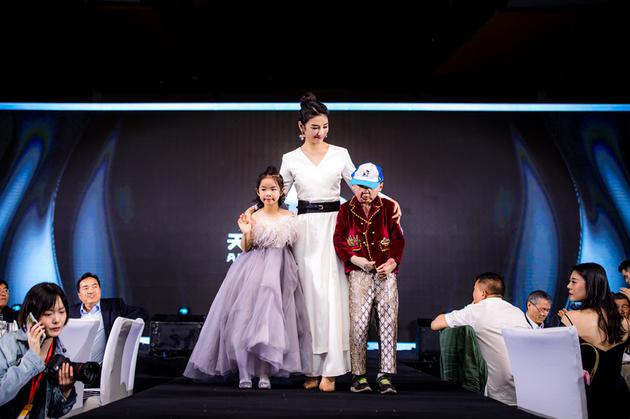 黄奕带着女儿、救助的小朋友走秀