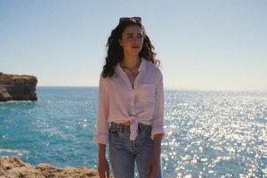 海辺で撮影された女性の全身写真。