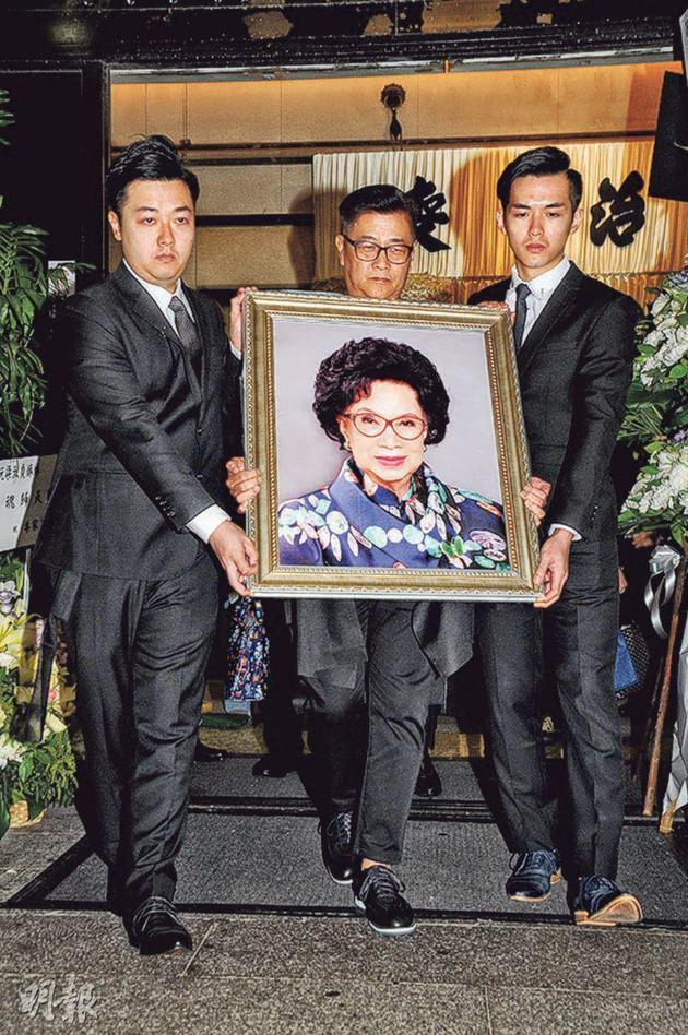 梁舜燕的遗照，由儿子阮惠源（中）及两名孙儿阮浩锋（左）和阮浩棕（右）负责捧着。