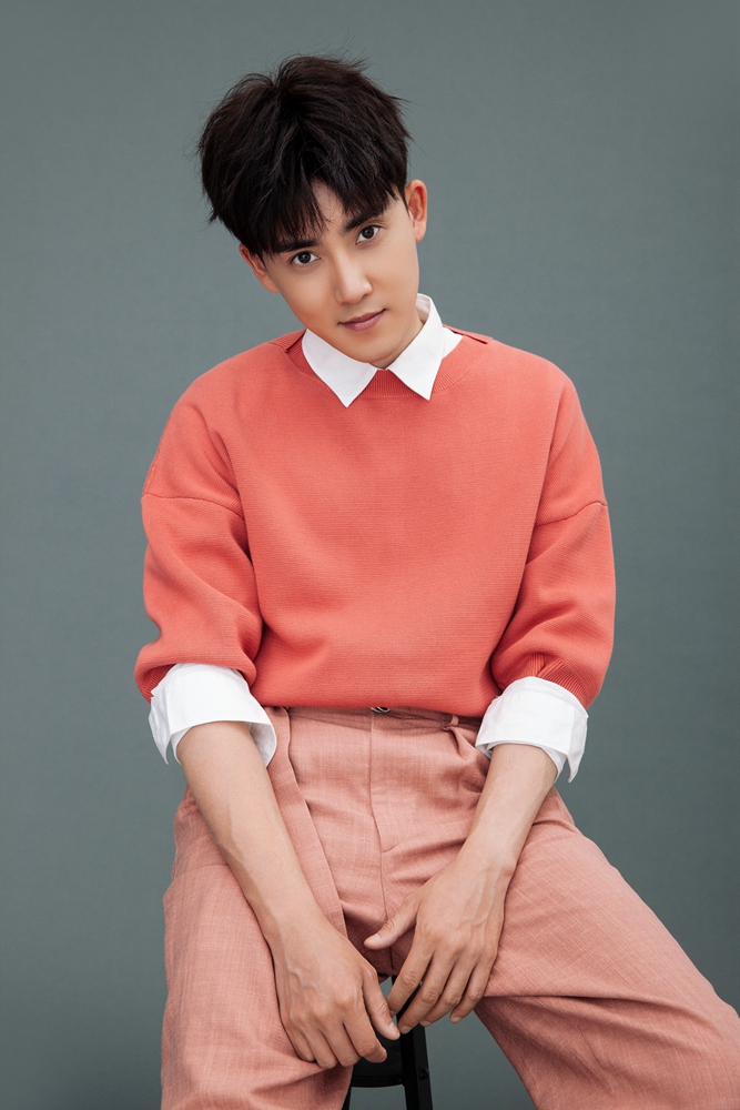 照片中张睿白色衬衫打底外搭粉色t恤简约优雅尽显青春活力,或低眉浅笑