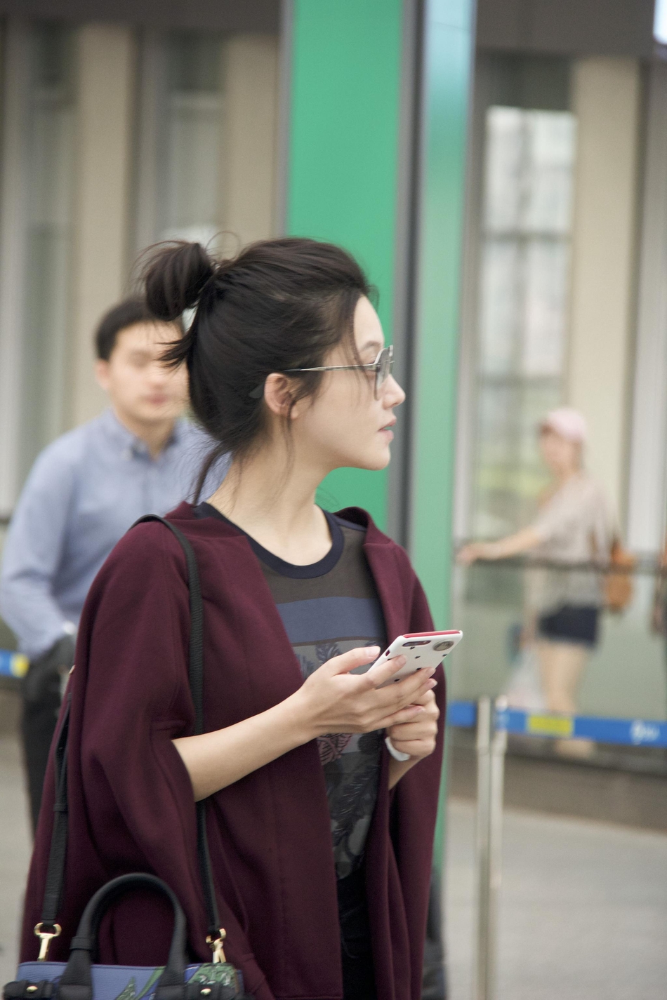 杨子姗搭红色披肩现身机场 素颜配丸子头好随性