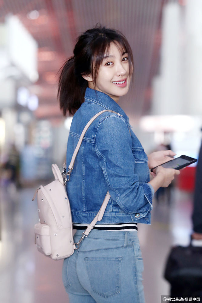 李菲儿素颜牛仔装现身机场扎马尾显青春活力