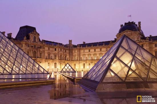 夜晚时分，卢浮宫的正门依旧灯火通明。卢浮宫是世界上最大的艺术博物馆。