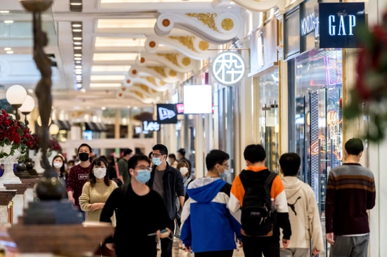 人们在上海某购物中心带着口罩逛街购物 图片来源：Zhou Junxiang/AP