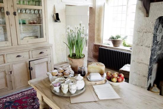 厨房里使用不匹配的老式陶器和家具，与现代厨房的设施看起来却十分融洽。