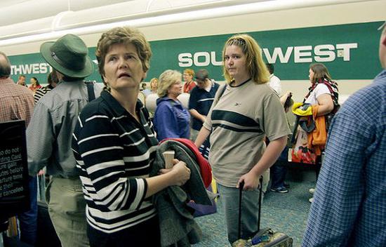2002年12月13日，乘客们在佛罗里达州奥兰多国际机场的低价航空公司西南航空公司售票处等候排队。
