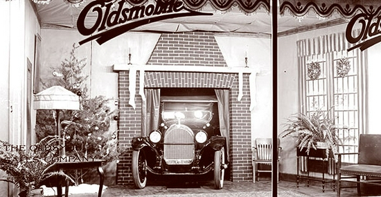 　　上世纪20年代，奥兹莫比尔（Oldsmobile）的假日橱窗展示了一辆老式汽车从壁炉开进客厅的场景 　　图片来源：victoriana.com