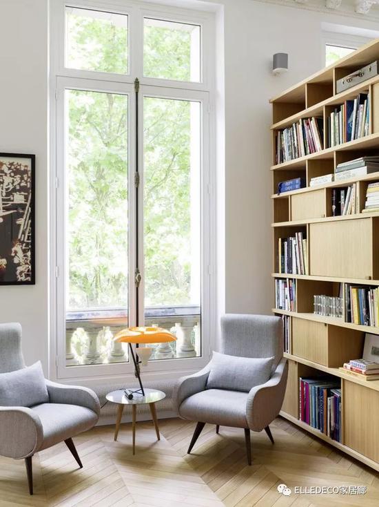 厨房临窗的一侧设了阅读角。两张意大利古董扶手椅来自上世纪50年代。中间的Lalinde小圆几出自巴黎的Sentou画廊。橙色台灯由Gino Sarfatti设计，来 自Flos。